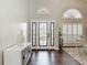 Bright foyer with ornate front door, transom windows, and hardwood floors at 6716 Frontier Ln, Tampa, FL 33625