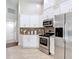 Well-lit kitchen showcasing stainless steel appliances, granite countertops, and bright white cabinetry at 6716 Frontier Ln, Tampa, FL 33625