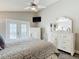 Bright primary bedroom with white furniture, a ceiling fan, and a glass door to the backyard at 6716 Frontier Ln, Tampa, FL 33625