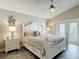 Spacious primary bedroom with a beautiful white bed, dark floors, and a glass door leading to the outside at 6716 Frontier Ln, Tampa, FL 33625