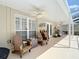 Covered patio with ceiling fans, seating and an outdoor grill, creating a comfortable outdoor living area at 6716 Frontier Ln, Tampa, FL 33625