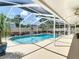 Inviting screened-in pool area with crystal-clear water, surrounded by lush landscaping and shaded seating at 6716 Frontier Ln, Tampa, FL 33625