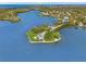 Incredible aerial view of waterfront house on point lot, featuring lush landscaping, pool, and dock at 7049 Peninsular Dr, New Port Richey, FL 34652