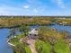 Breathtaking aerial of waterfront estate with beautiful trees, a long driveway, and meticulous landscaping at 7049 Peninsular Dr, New Port Richey, FL 34652