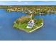Stunning aerial view of waterfront home with lush landscaping, private pool, and dock on a point lot at 7049 Peninsular Dr, New Port Richey, FL 34652