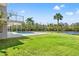 Expansive backyard featuring a covered patio, outdoor pool, and gorgeous waterfront views for exceptional outdoor living at 7049 Peninsular Dr, New Port Richey, FL 34652