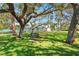 Enjoy waterfront living with a shady backyard bench swing and lush landscaping, perfect for relaxing and entertaining at 7049 Peninsular Dr, New Port Richey, FL 34652