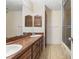 Bathroom with a double sink, wooden drawers and cabinet doors, a tiled floor and a shower with glass doors at 7049 Peninsular Dr, New Port Richey, FL 34652