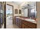 Bathroom with a double sink, wooden drawers and cabinet doors, a tiled floor and a shower with glass doors at 7049 Peninsular Dr, New Port Richey, FL 34652