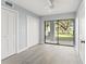 Bright bedroom with gray floors and sliding glass doors providing a view of the landscaped backyard at 7049 Peninsular Dr, New Port Richey, FL 34652