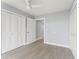 Bedroom featuring light gray floors, modern ceiling fan and ample closet space at 7049 Peninsular Dr, New Port Richey, FL 34652