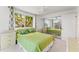 A bedroom features a mirrored closet, window views, and bed dressed in green linens at 7049 Peninsular Dr, New Port Richey, FL 34652