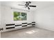 Bright bedroom with a ceiling fan, neutral carpeting, and built-in storage under a window at 7049 Peninsular Dr, New Port Richey, FL 34652