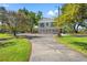Stunning home exterior with well-manicured lawn and ample parking, nestled among beautiful mature trees at 7049 Peninsular Dr, New Port Richey, FL 34652