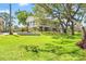 Waterfront home showing the beautiful, landscaped lawn and mature trees, offering serene outdoor living in a desirable location at 7049 Peninsular Dr, New Port Richey, FL 34652