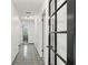 Long hallway with tiled flooring and doors, leading to various rooms within the house at 7049 Peninsular Dr, New Port Richey, FL 34652