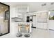 Bright white kitchen with bar seating and access to a waterfront view at 7049 Peninsular Dr, New Port Richey, FL 34652