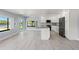 Open-concept kitchen features an island, modern finishes, lake views, and neutral colored countertops and cabinets at 7049 Peninsular Dr, New Port Richey, FL 34652
