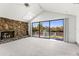 Cozy living room with stone fireplace, carpeted flooring and sliding glass doors with water views at 7049 Peninsular Dr, New Port Richey, FL 34652