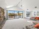 Bright living room with a stone fireplace, skylight, and large sliding doors overlooking the water at 7049 Peninsular Dr, New Port Richey, FL 34652