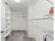 Walk-in closet with carpet flooring, white walls, wire shelving, and a ceiling access panel at 7049 Peninsular Dr, New Port Richey, FL 34652