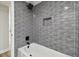 Gray tiled shower and updated bathtub with rainfall shower head in a bathroom at 7804 N Whittier St, Tampa, FL 33617