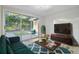 Cozy living room featuring natural light, hardwood flooring, and a sliding glass door with access to the backyard at 7804 N Whittier St, Tampa, FL 33617