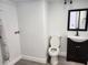 Bathroom featuring new floors, vanity, mirror and lighting, with toilet and washer-dryer hookups at 8707 Sailmaker Ct, Tampa, FL 33615