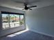 Bright bedroom featuring a large window with community view and a modern ceiling fan at 8707 Sailmaker Ct, Tampa, FL 33615