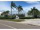 Gated community entrance with lush landscaping and mature palm trees on a sunny day at 8707 Sailmaker Ct, Tampa, FL 33615