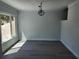 Bright dining room featuring new gray floors, decorative light fixture, and a large window offering plenty of natural light at 8707 Sailmaker Ct, Tampa, FL 33615