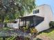 Charming home exterior with a screened lanai, white fence, and lush landscaping at 8707 Sailmaker Ct, Tampa, FL 33615