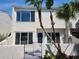 Charming two-story home with stucco facade and tropical landscaping. Updated windows and entry gate at 8707 Sailmaker Ct, Tampa, FL 33615
