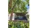 Exterior view of a cozy screened lanai with seating and lush landscaping at 8707 Sailmaker Ct, Tampa, FL 33615