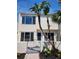 Charming two-story home with stucco facade and tropical landscaping. Updated windows and entry gate at 8707 Sailmaker Ct, Tampa, FL 33615