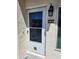A close-up of the front door with screen, number plate, and exterior light fixture at 8707 Sailmaker Ct, Tampa, FL 33615