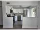 Updated kitchen with white cabinets, stainless steel appliances, tile backsplash, and pass through at 8707 Sailmaker Ct, Tampa, FL 33615