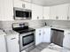 Updated kitchen featuring white cabinets, stainless steel appliances, and stylish backsplash at 8707 Sailmaker Ct, Tampa, FL 33615
