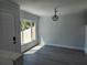 Bright living room with updated flooring, neutral paint, modern light fixture, and large window at 8707 Sailmaker Ct, Tampa, FL 33615