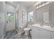 Bright bathroom with a white vanity, toilet, shower, and patterned tile floors at 8833 Bel Meadow Way, Trinity, FL 34655