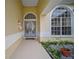 Home exterior with a beautiful doorway that leads to a decorative window at 8833 Bel Meadow Way, Trinity, FL 34655