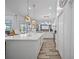 Open concept kitchen with white cabinets, large island, and views of the outdoor pool area at 8833 Bel Meadow Way, Trinity, FL 34655