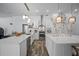 Modern white kitchen with stainless steel appliances, spacious countertops, and stylish pendant lighting at 8833 Bel Meadow Way, Trinity, FL 34655