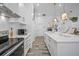 Bright kitchen with white cabinets, marble countertops, and modern stainless steel appliances at 8833 Bel Meadow Way, Trinity, FL 34655