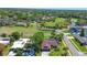 Aerial view of a one story home with a screened in pool, golf course, and lush landscaping in a verdant neighborhood at 10 Arbor Ln, Oldsmar, FL 34677