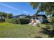 A cozy backyard with a screened-in patio, lounge chairs, and manicured hedges at 10 Arbor Ln, Oldsmar, FL 34677