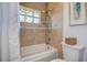 Cozy bathroom with tiled walls, shower, and glass block window providing natural light at 10 Arbor Ln, Oldsmar, FL 34677