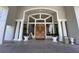 Elegant entrance with ornate wooden doors, towering columns, and expansive windows, creating a grand arrival at 10 Arbor Ln, Oldsmar, FL 34677