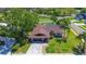 Aerial view of a charming single-story home featuring a stone chimney and lush, green lawn at 10 Arbor Ln, Oldsmar, FL 34677