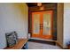 Close-up of a bright orange front door with decorative glass panels and bench seating at 10 Arbor Ln, Oldsmar, FL 34677